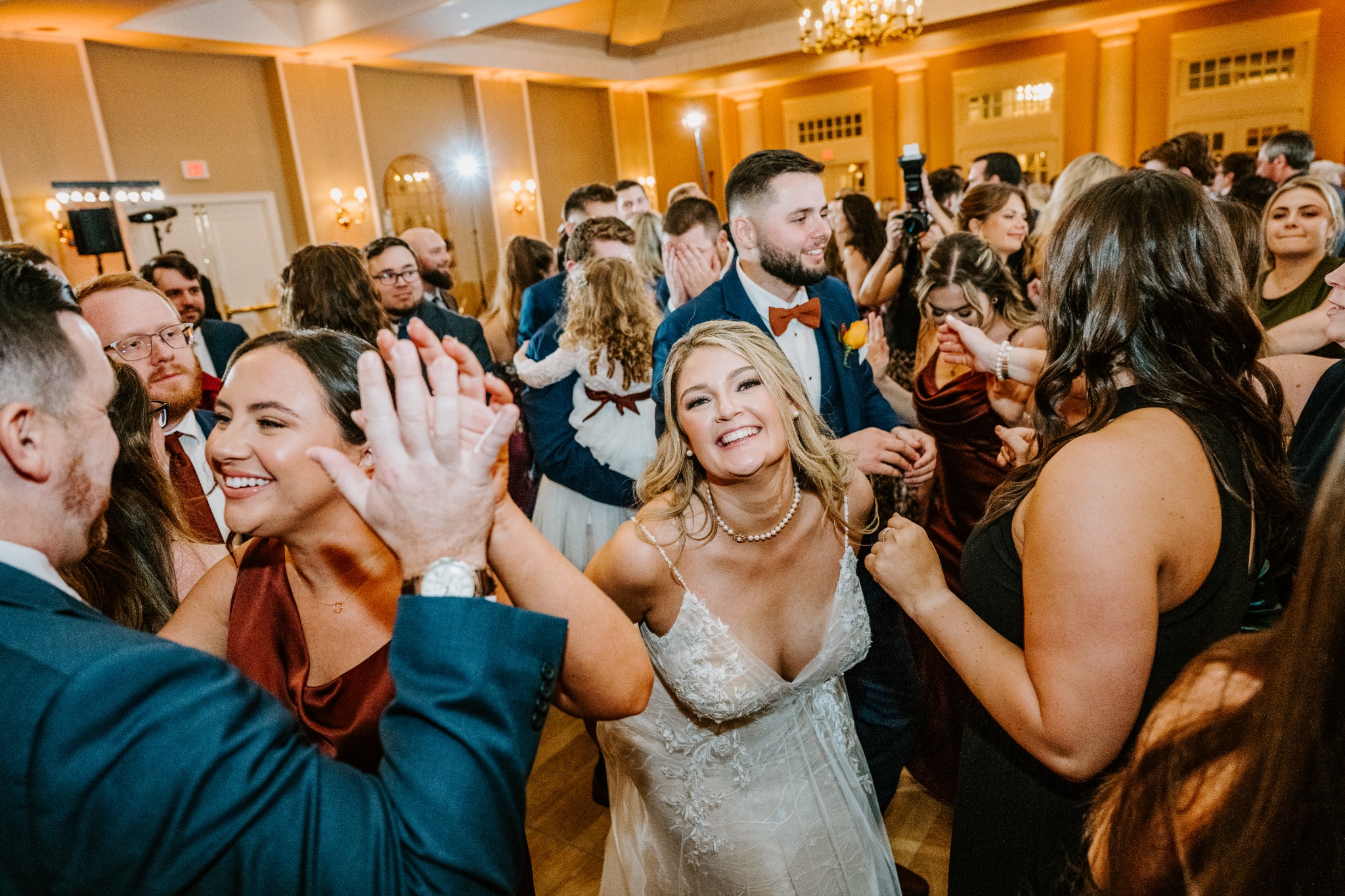 A newlywed couple celebrating together on a packed wedding dance floor