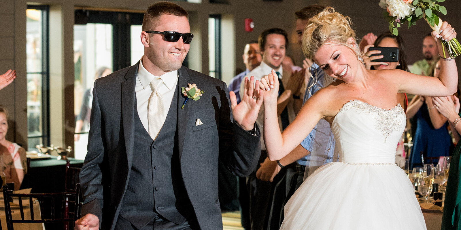 Newlyweds dancing together as their guests celebrate around them