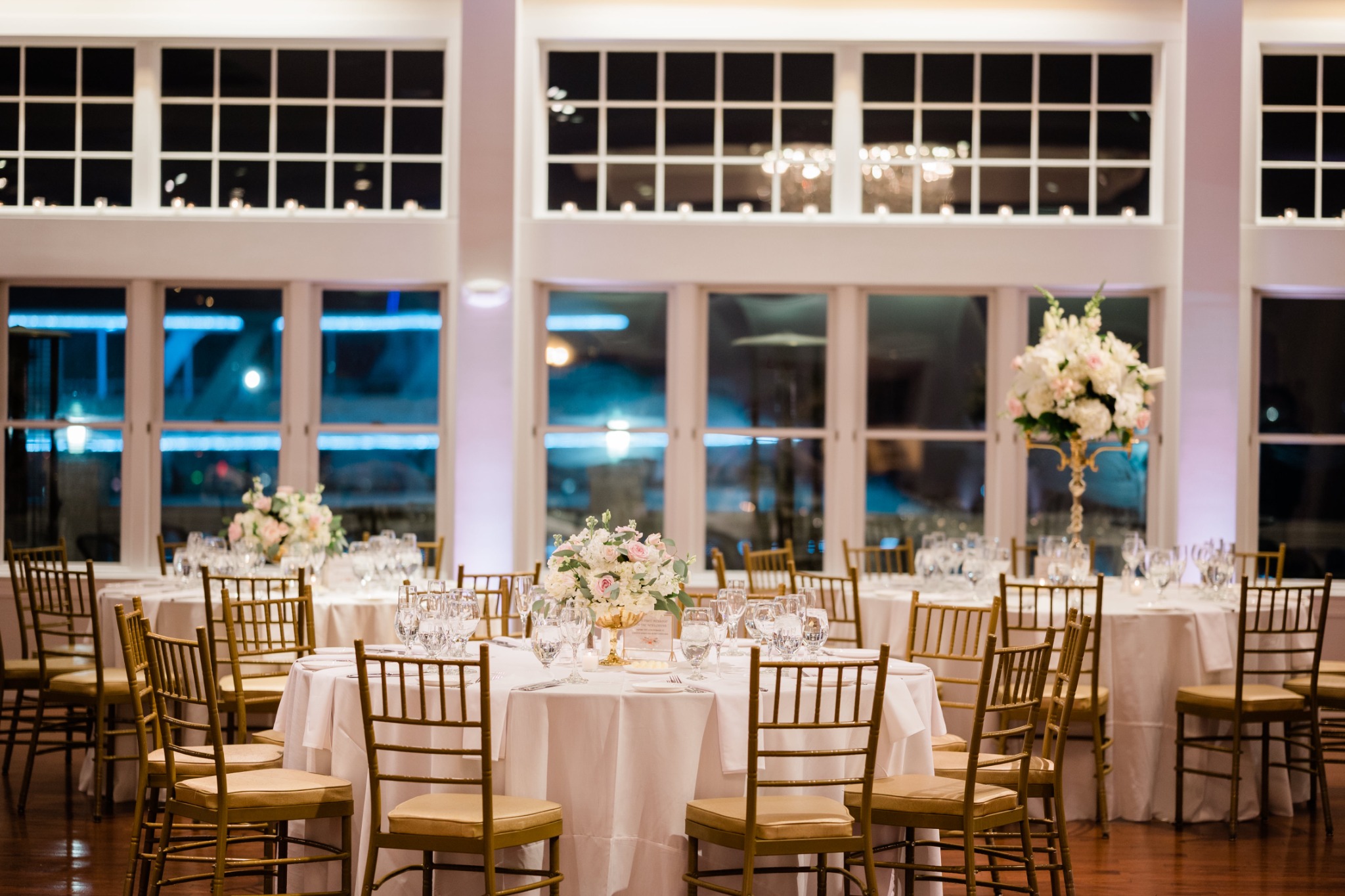 An elegant wedding reception room prepared with floral centerpieces and finished tables